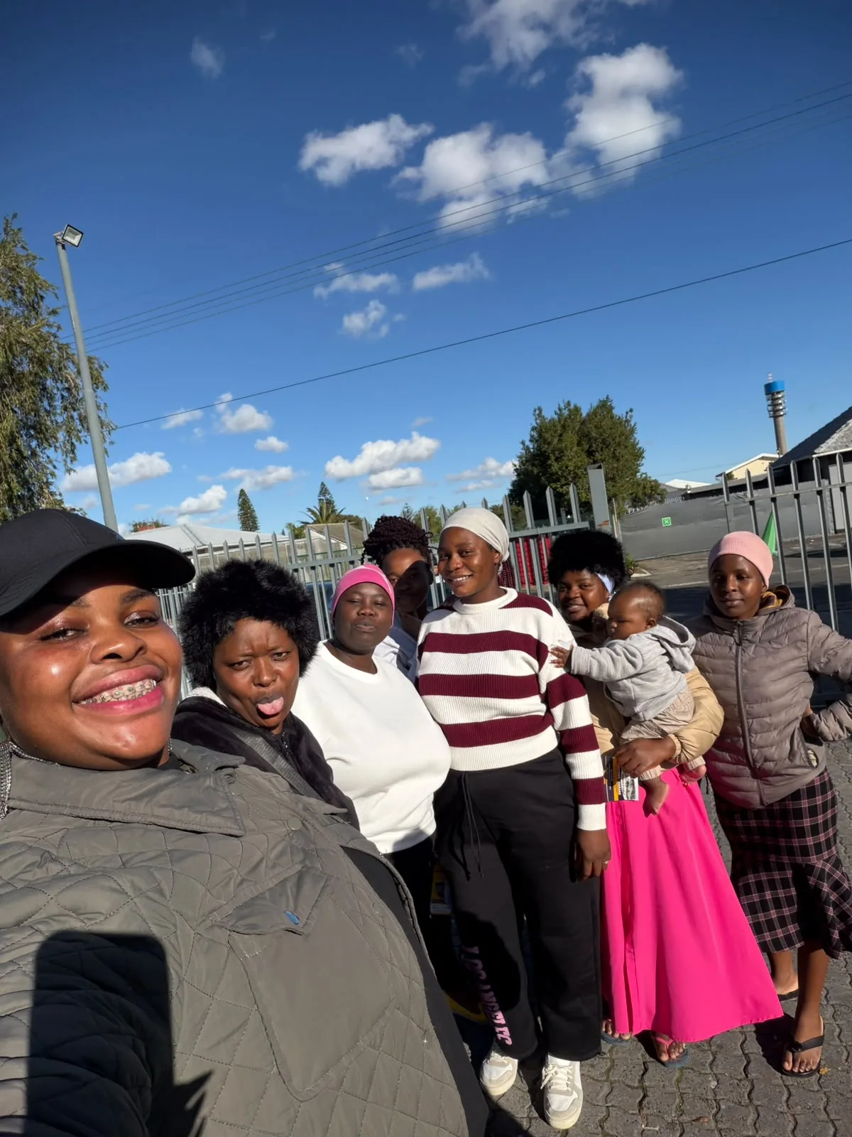 A group taking an outdoor selfie under a blue sky in a photograph supplied with the relocation initiative